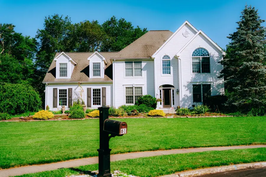 A suburban house exterior with a lush restored green lawn after renovation