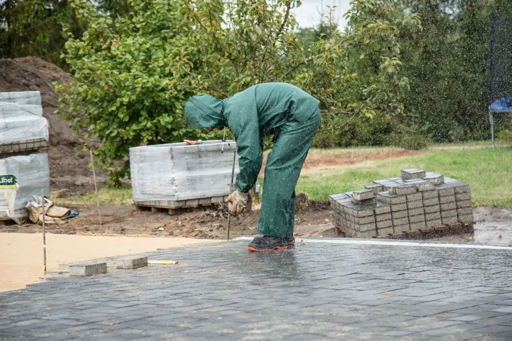 Worker laying paving stones