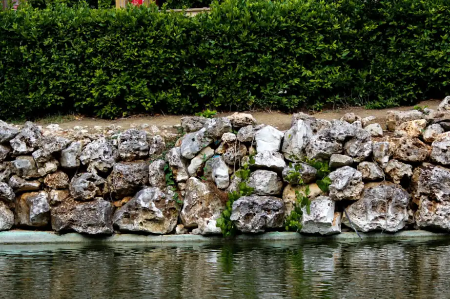 A stacked stone retaining wall built into a landscaped garden slope